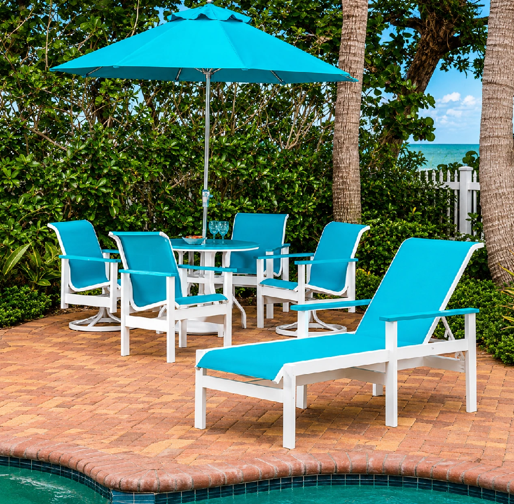 Resort pool deck featuring turquoise Marine Grade Polymer outdoor dining chairs and chaise lounges under a matching umbrella for a vibrant tropical atmosphere.